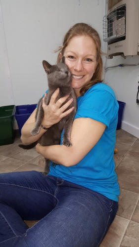 Amber with a big smile holding Poppy - a little gray cat